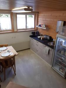a small kitchen with a table and a refrigerator at Gasthof Rössli Gondiswil in Gondiswil