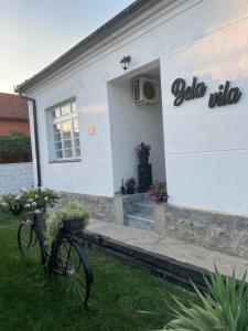 una bicicleta estacionada frente a un edificio blanco en BELA VILA en Negotin