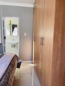 a bedroom with a bed and a bathroom with a sink at Luxuries Penthouse in Nelspruit