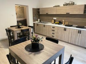 una cocina con mesas y sillas de madera y una mesa con flores. en BELA VILA en Negotin