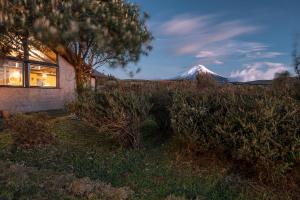a snow covered mountain in the distance behind a house at Chilcabamba Lodge in Machachi