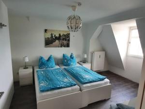 a bedroom with a bed with blue pillows at Gästewohnung Eulennest 
