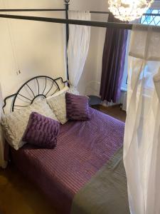 a bedroom with a bed with purple pillows on it at Carn View Located Nr Heartlands & Carn Brea in Pool
