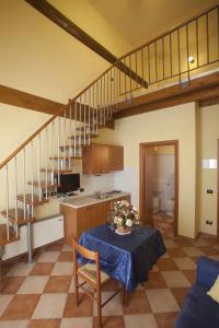a living room with a table and a kitchen and stairs at Agriturismo Il Bove in Reggio Emilia