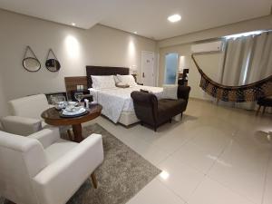 a living room with a bed and a table and chairs at Hotel Palace Santarém Brasil in Santarém