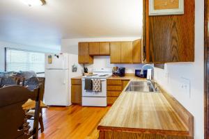 cocina con armarios de madera y nevera blanca en Lake House First Floor, en Vassalboro