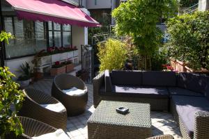 a patio with a couch and chairs and a table at Hotel Marinella in Celle Ligure