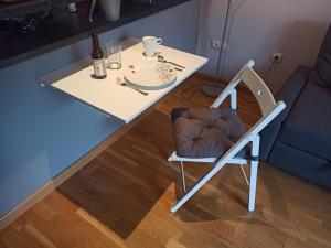 un tavolo bianco con una sedia e un tavolo con un piatto di Acogedor y tranquilo a Valladolid
