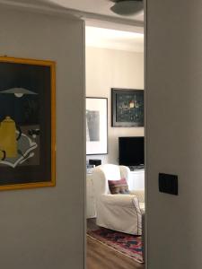 a living room with a white chair and a mirror at dietro il teatro modena in Genova