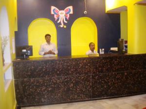 two men standing at a counter in a restaurant at Ganpati Guest House in Varanasi