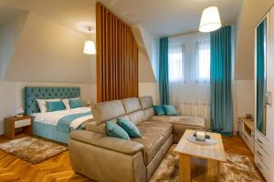 uma sala de estar com um sofá e uma cama em Apartmani Stojanović Zlatibor em Zlatibor