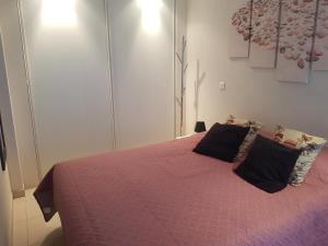 um quarto com uma cama rosa e 2 almofadas em Beau appartement avec garage fermé em Beausoleil