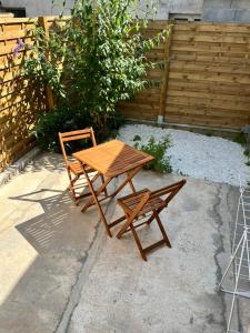 a wooden table and chair next to a wooden fence at Logia in Ploërmel