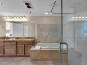 a bathroom with a tub and a glass shower at Jade East Towers 0640 by Newman-Dailey in Destin +4 photos