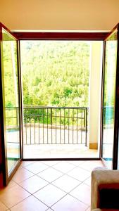 eine offene Tür zu einem Balkon mit Aussicht in der Unterkunft La finestra sul parco in Villetta Barrea