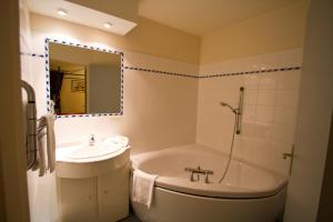 a bathroom with a sink and a tub and a mirror at Hôtel Restaurant La Promenade in Gourdon-en-quercy +17 photos