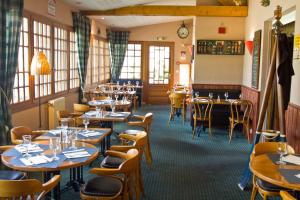 ein Restaurant mit Tischen und Stühlen in einem Zimmer in der Unterkunft Hôtel Restaurant La Promenade in Gourdon-en-quercy