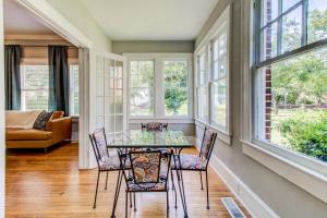 a dining room with a table and chairs and windows at Historic Charmer in Wilmington