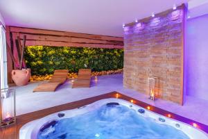 una bañera de hidromasaje en una habitación con una pared de ladrillo en Hibrido Boutique Hotel & Spa, en Sciacca