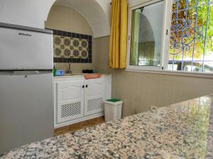 a kitchen with a white refrigerator and a window at The Shell Of The Beach in Hammamet