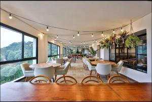 - une salle à manger avec des tables, des chaises et des fenêtres dans l'établissement Carpe Diem Spa & boutique, à Campos do Jordão