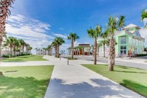 une passerelle avec des palmiers devant un bâtiment dans l'établissement Beachview 321, à Gulf Shores