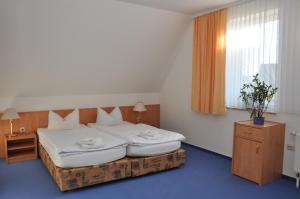 a hotel room with a bed and a window at Pension Lindenhof in Kromsdorf