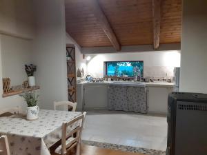 eine Küche mit einem Tisch und einem TV an der Wand in der Unterkunft Gatti di Langa in Dogliani