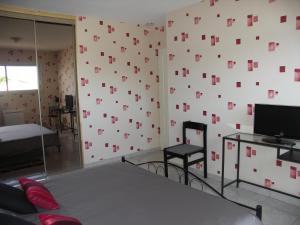 ein Schlafzimmer mit einer Wand mit rosa Quadraten darauf in der Unterkunft Chambres d'Hôtes Le Saint Ô Détente in Saint-Orens-de-Gameville