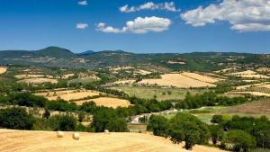 un campo con fardos de heno en la cima de una colina en Il Girasole Terzuolo, en Manciano