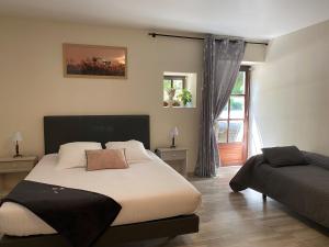 Un dormitorio con una cama grande y una ventana en Maison Belles Pierres, en Montagny-lès-Beaune