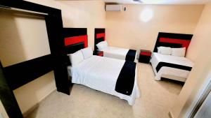 1 dormitorio con 2 camas y 2 sillas en Hotel Jardín Cancún en Cancún
