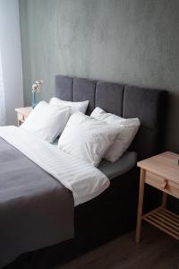 een bed met witte lakens en kussens erop bij Apartaments Nr.33 (Viesu Nr.3) in Talsi
