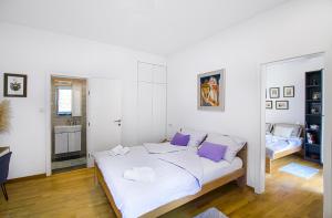 a bedroom with a large white bed with purple pillows at F9 and New F9 in Zagreb