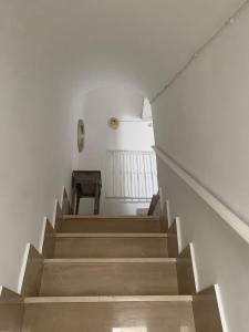 a staircase in a white room with a table at Casa Sunshine in Ostuni