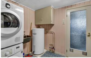a kitchen with a washing machine and a washer at Arendalsuka - Fin enebolig, sentralt og sjønært,gratis parkering 4 rom 3 bad 2 stuer in Arendal