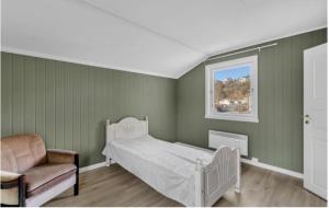 a bedroom with a bed and a chair and a window at Arendalsuka - Fin enebolig, sentralt og sjønært,gratis parkering 4 rom 3 bad 2 stuer in Arendal
