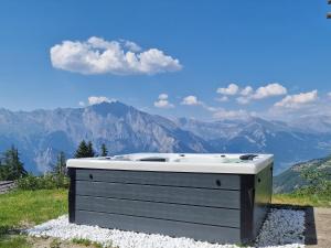 a bath tub sitting on top of a hill with mountains at Chalet la Chance in La Tzoumaz