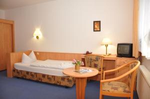 a hotel room with a bed and a small table at Pension Lindenhof in Kromsdorf