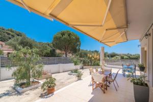 un patio con tavolo e sedie sul balcone. di Stergios House a Kalamákion