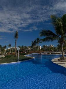 a large swimming pool with palm trees in a resort at Hawana salalah Apartment Mimosa in Salalah