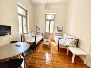 uma sala de estar com um sofá e uma mesa em Princess Amalia Vintage Apartment em Atenas