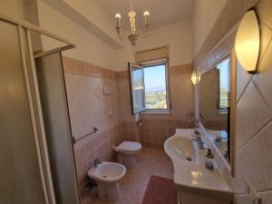 ein Badezimmer mit Waschbecken, Toilette und Spiegel in der Unterkunft Miramare Apartment in Acquedolci + 16 Fotos