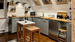 a kitchen with stainless steel appliances and a bottle of wine at Business Apartment bei Magdeburg in Biederitz