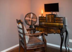 BiederitzにあるBusiness Apartment bei Magdeburgのデスク、ファン、椅子が備わる客室です。