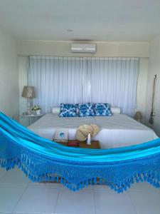 a bedroom with a large bed with a blue rope around it at Casa Alto do Cunhau in Barra do Cunhau