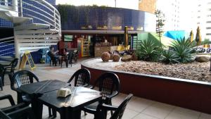 福塔莱萨Apartamento Praia de Iracema的建筑物内有桌椅的餐厅