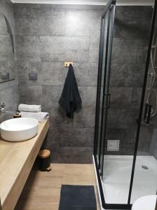 a bathroom with a sink and a shower at Dom nad jeziorem Strażym in Zbiczno