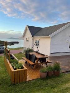 una terraza de madera con mesa de picnic y una casa en Frugga Feriehus og leilighet, en Straumsjøen