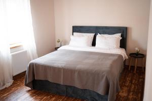 - une chambre dotée d'un grand lit avec des draps et des oreillers blancs dans l'établissement Apartaments Nr. 33 ( Viesu Nr. 4), à Talsi